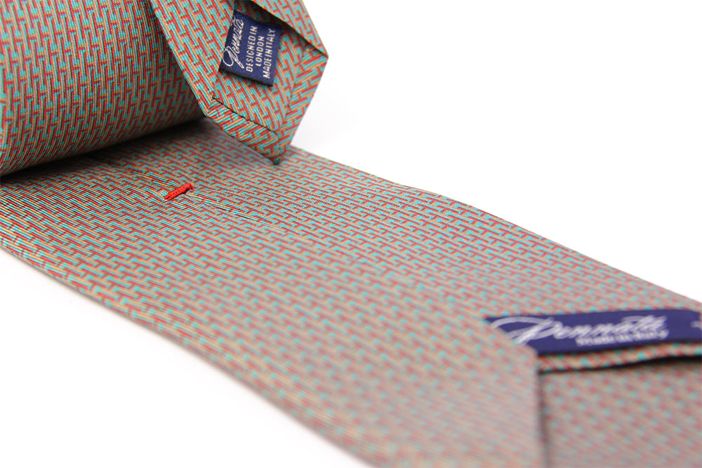Close up of a patterned designers silk tie turquoise