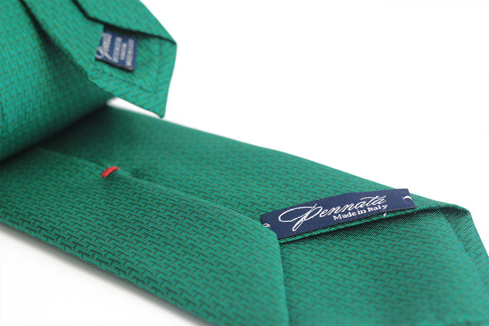 A green necktie with a cross-hatched pattern, displayed on a plain background.