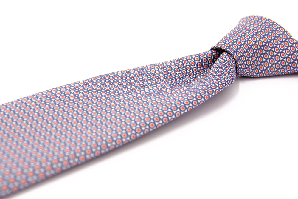 A purple tie with a geometric pattern of circles and dots on a white background, displayed in a folded and unfolded configuration.