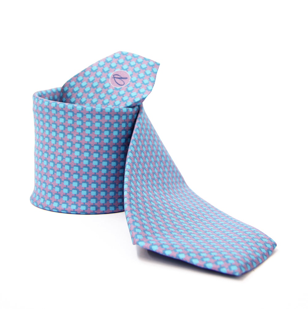 A patterned silk tie with a combination of violet and blue colors, displayed in a folded and unfolded configuration.