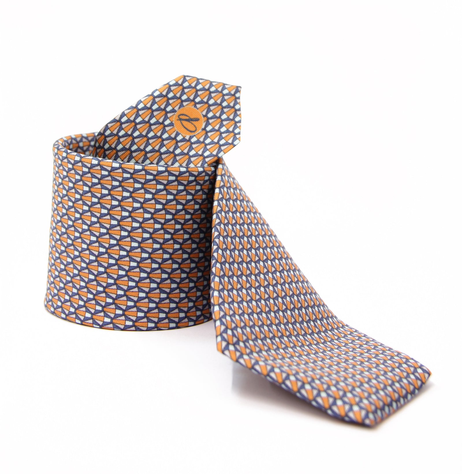 A silk tie with a geometric pattern in orange and white colors, displayed on a white background.