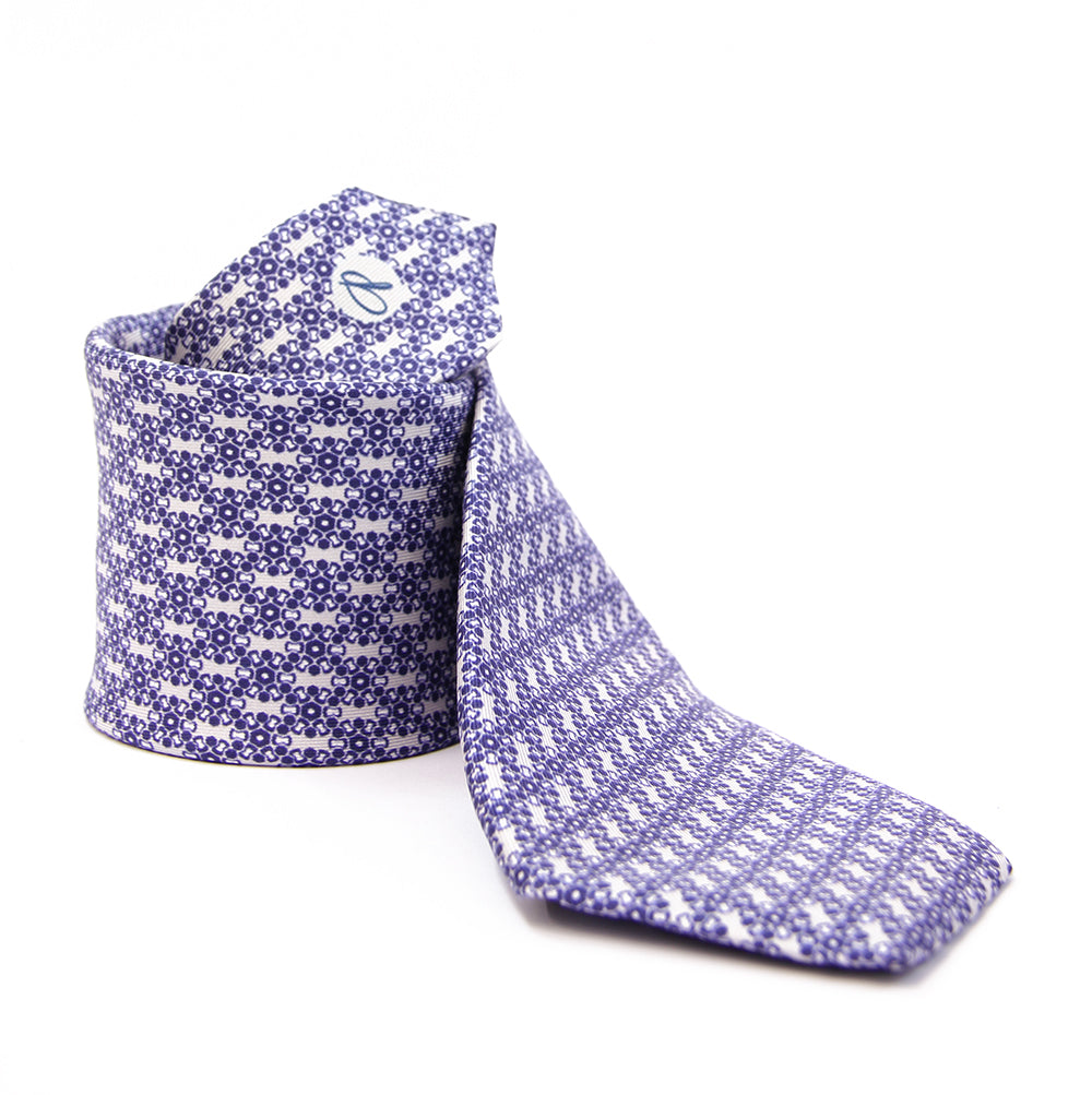 A silk tie with a geometric hexagonal pattern in blue and white colors, displayed on a white background.