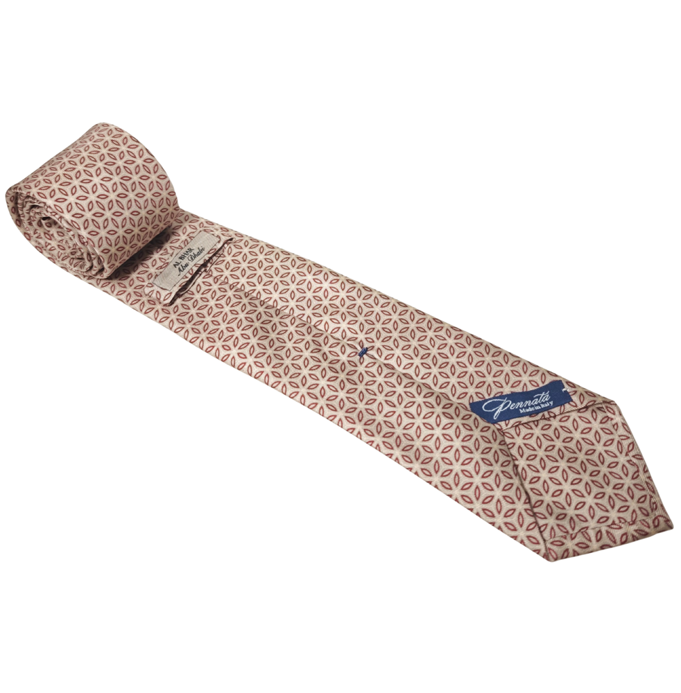 Patterned silk tie with a brand label on a white background