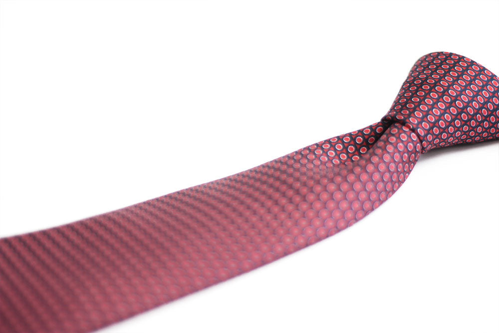 A red elegant tie with a geometric pattern of circles and dots displayed on a white background.