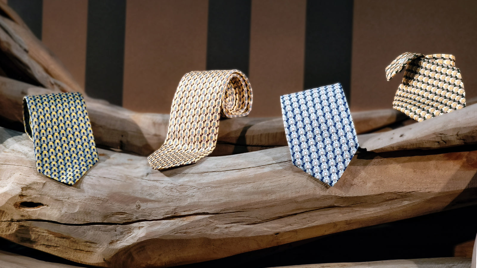 Four patterned silk ties on a wooden surface with a striped background