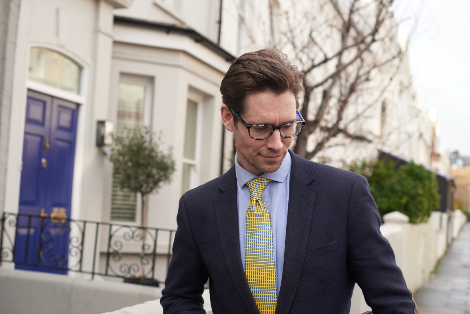 Man in a suit and tie walking outdoors with a building in the background